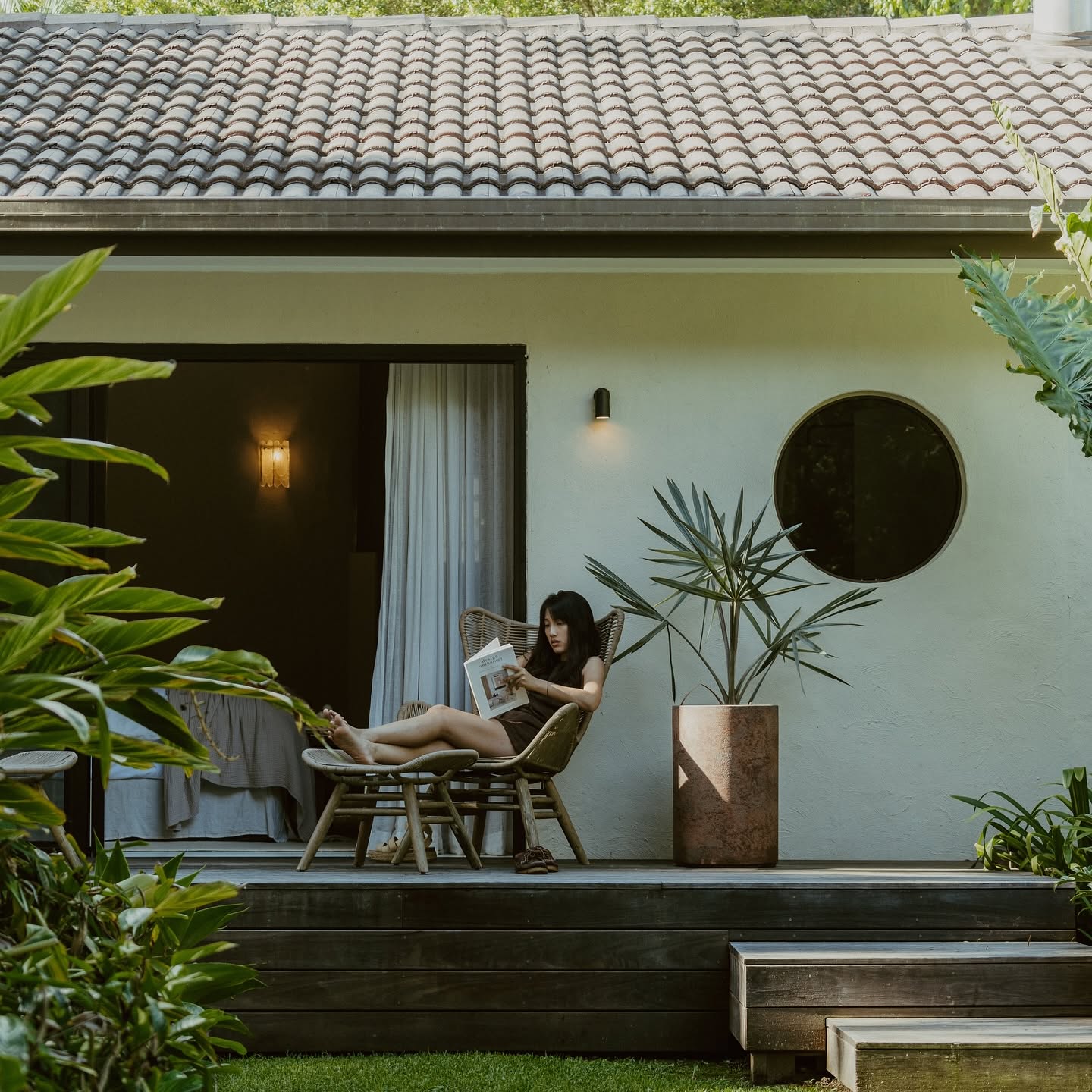Reading in the shade against the white plaster wall